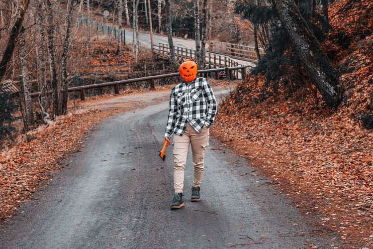 Full length of man standing on road in forest