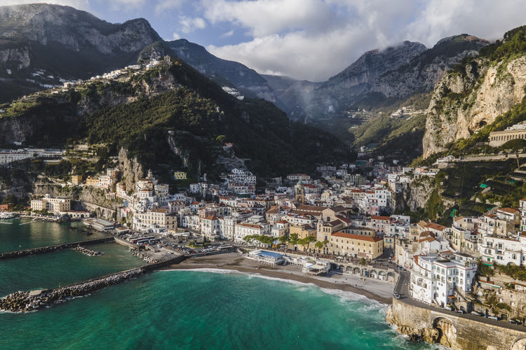 Italy, province of salerno, amalfi, drone view of town on amalfi coast with mountains in background