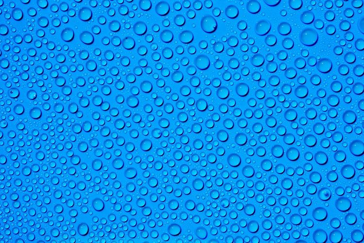 Full frame shot of water drops on blue background