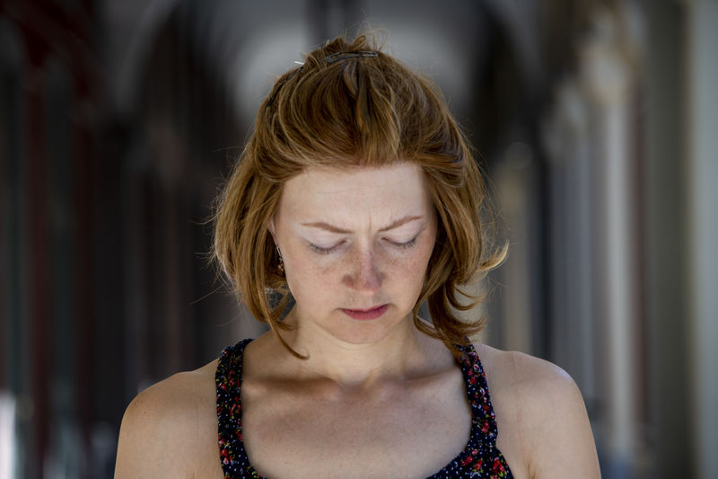Headshot of a young blond woman looking down