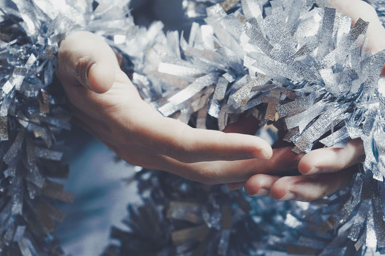 Close-up of hands holding tinsel
