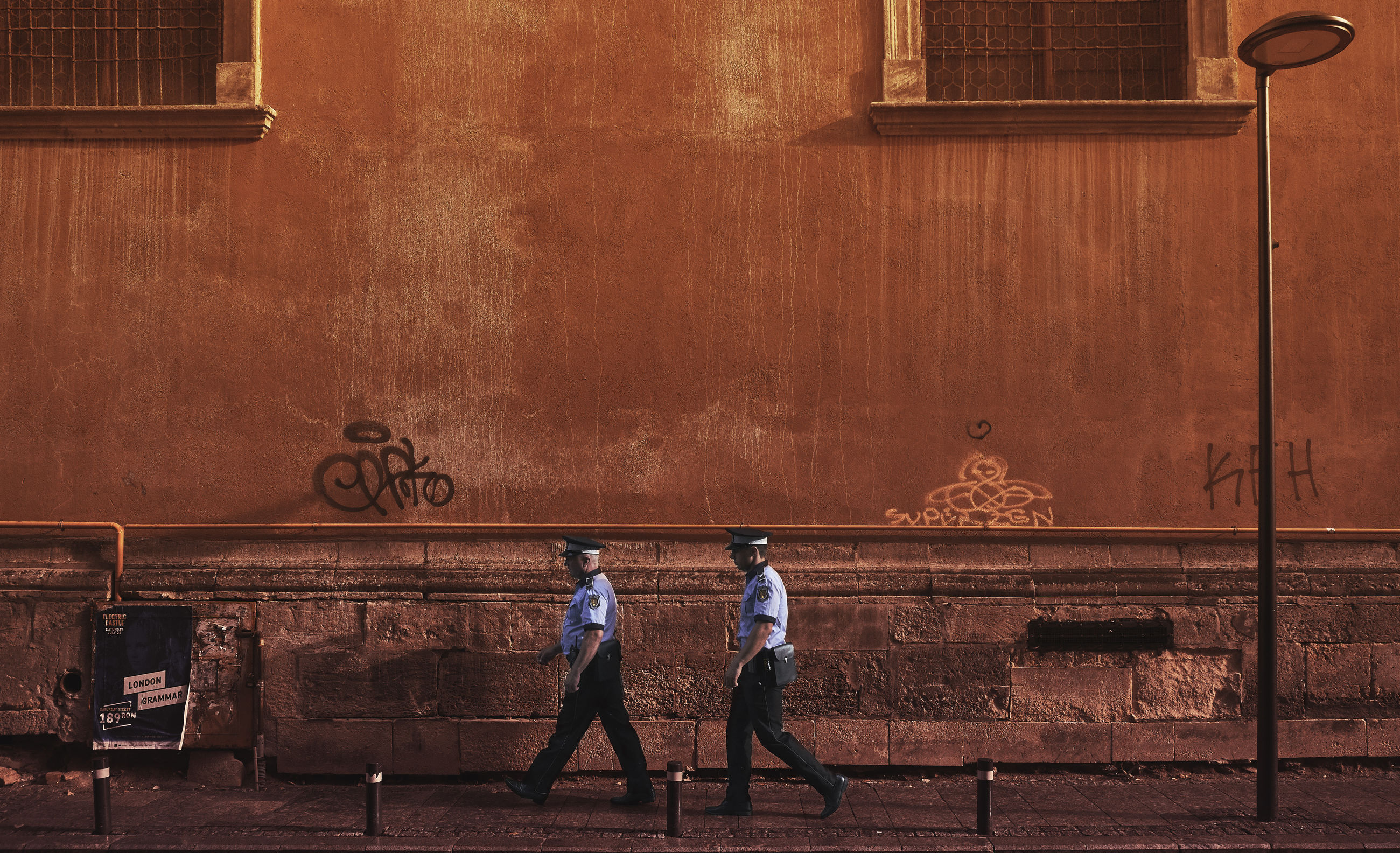 REAR VIEW OF TWO PEOPLE WALKING ON WALL