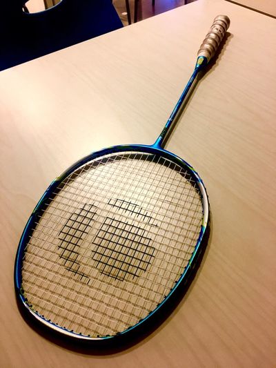 High angle view of badminton racket on wooden table