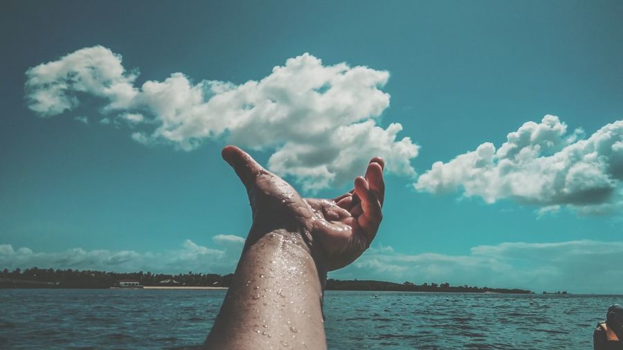 Midsection of person in sea against sky