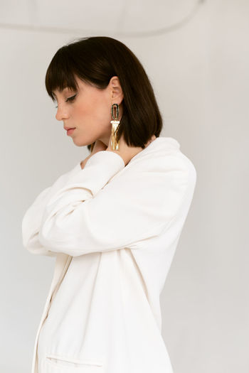 Side view of young woman against white background