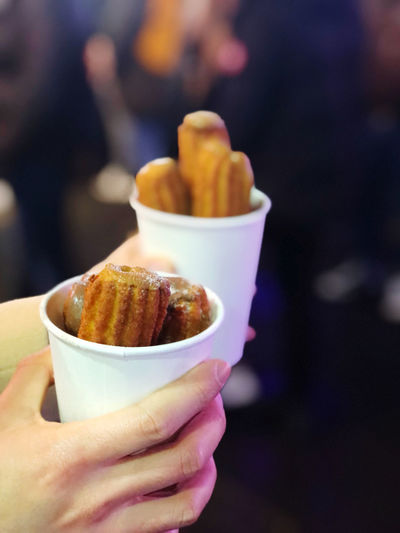 Close-up of hand holding churros in christmas market