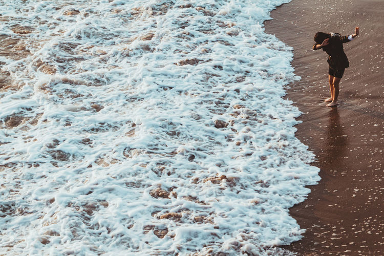 Full length of woman standing on shore at beach