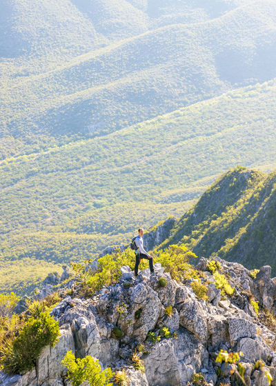 Man standing on rock by mountain