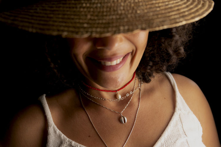 Close-up portrait of a woman wearing a hat against a black background. joy concept. 