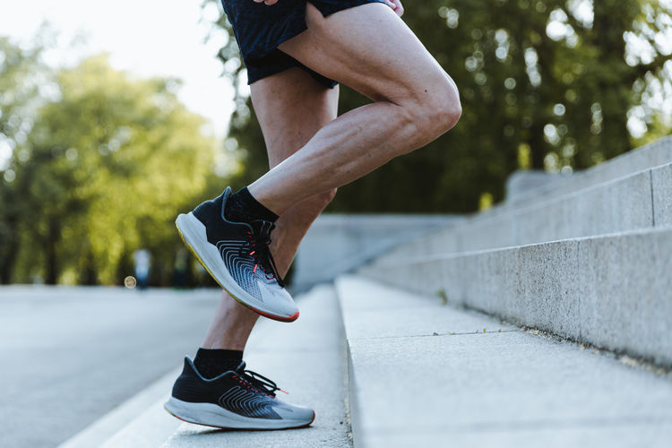 Close up of legs of a sporty man training up on the stairs