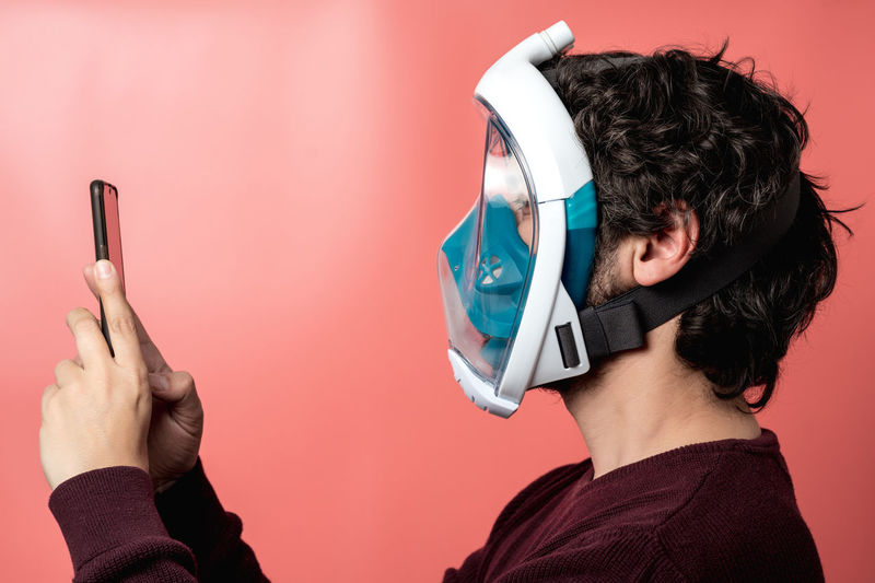 Man with underwater mask making a selfie on a colored background