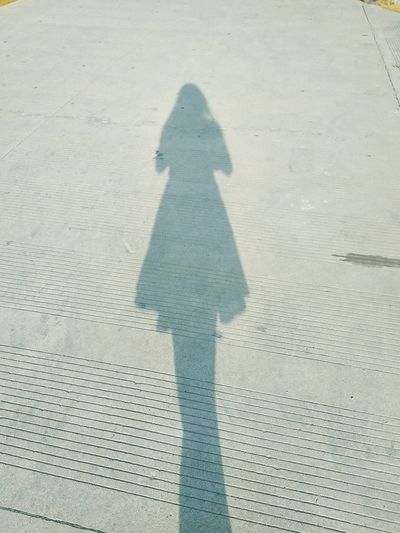 Shadow of person on footpath in city