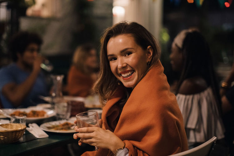 Portrait of smiling young woman sitting at restaurant