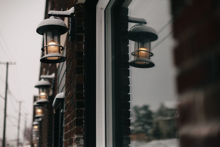 Low angle view of illuminated street light against building