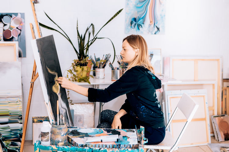Side view of woman painting at studio