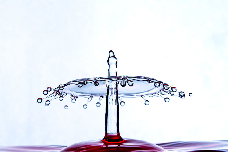 Close-up of water drop on glass against white background
