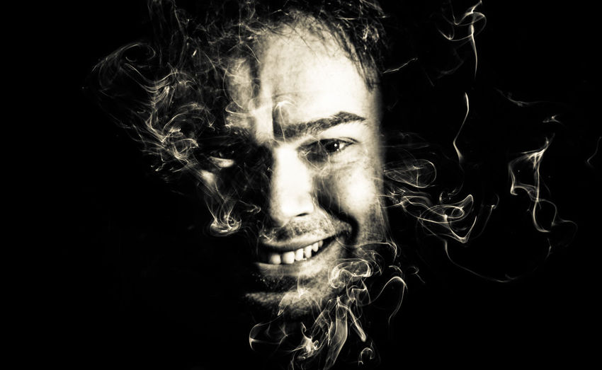 Portrait of young man against black background