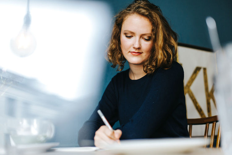 Portrait of blonde woman writing