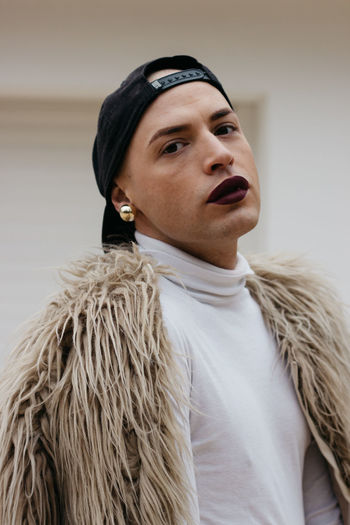 Close-up portrait of transgender man wearing cap with fake fur