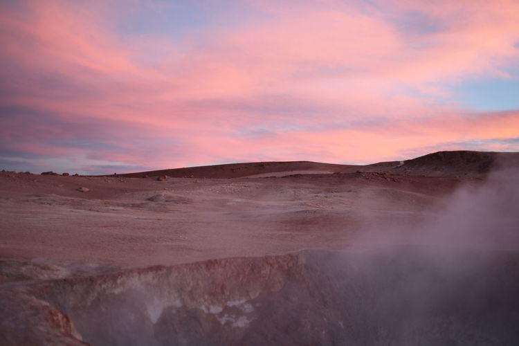 Steam rising from geyser at salar de uyuni during sunset