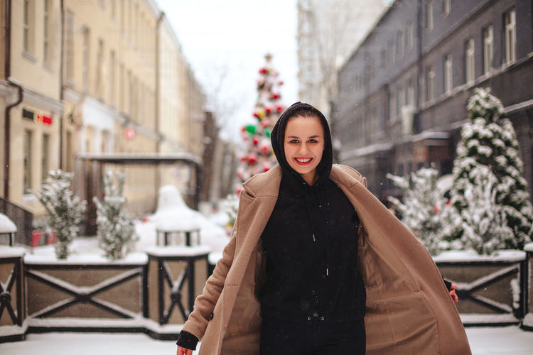 Portrait of smiling woman standing in snow