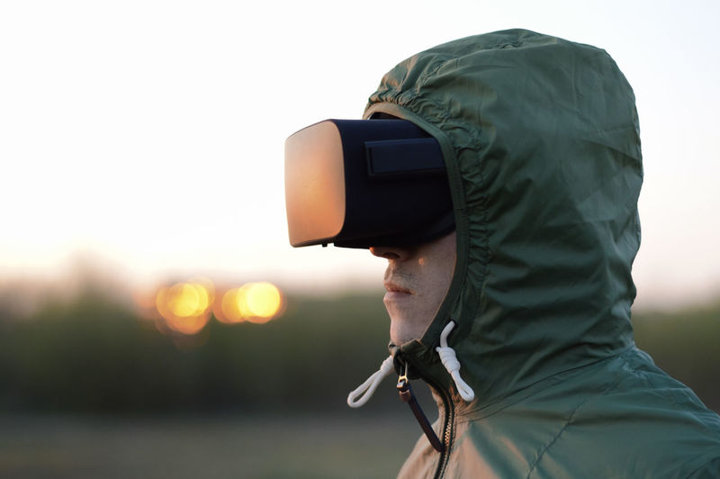 Man wearing virtual reality simulator standing on beach