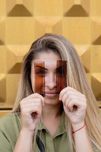 Portrait of beautiful young woman holding film reels