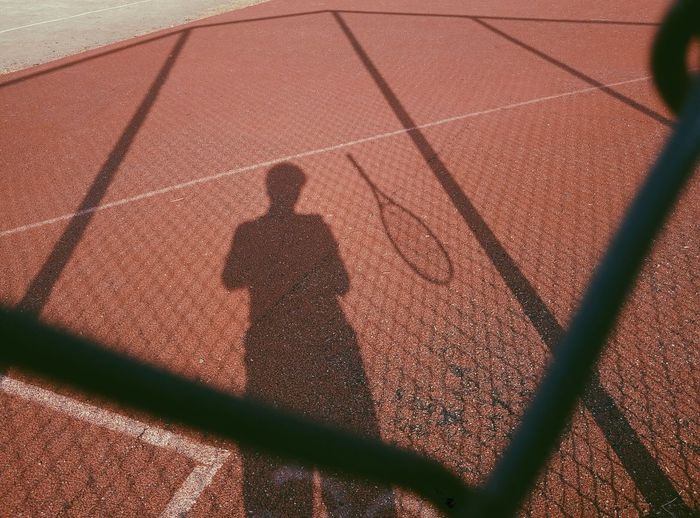 Shadow of man on tennis court