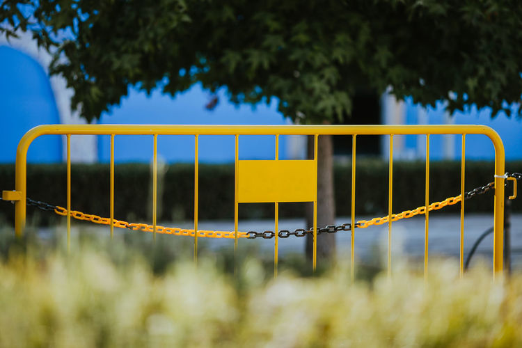 Close-up of yellow metallic barrier in park
