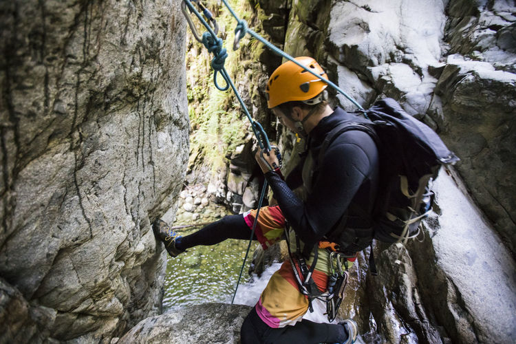 Man prepares to rappel down waterfall near vancouver, canada.