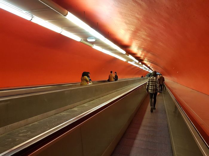 People walking on escalator in subway