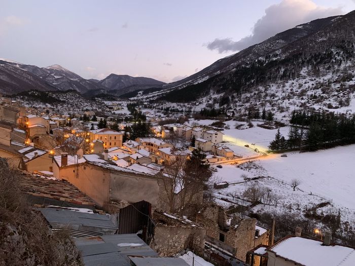 High angle view of townscape by mountains during winter