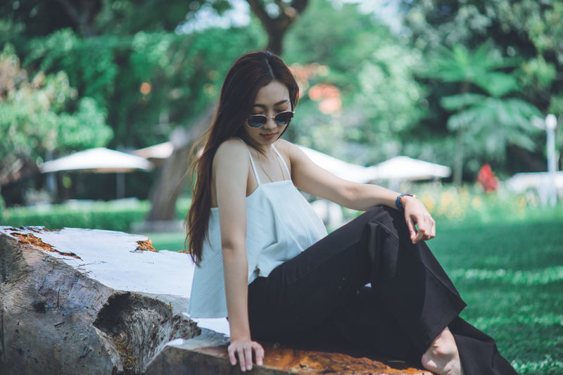 Young woman sitting on sunglasses