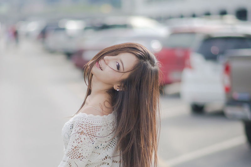 Beautiful young woman standing at parking lot