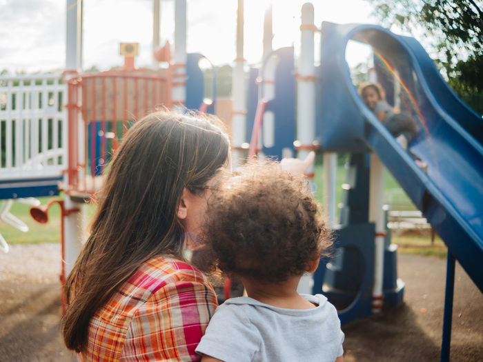 Mixed race family having fun at the kids park 