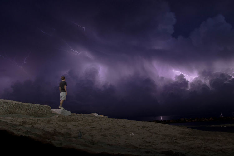 Full length of man standing on land against sky at night
