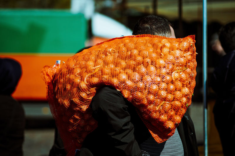 Man carrying onions in sack on shoulder