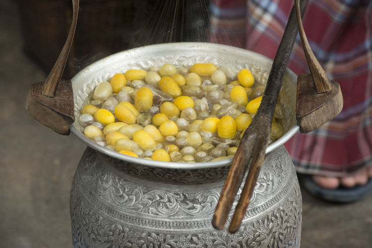 Silkworm cocoons boiling in container