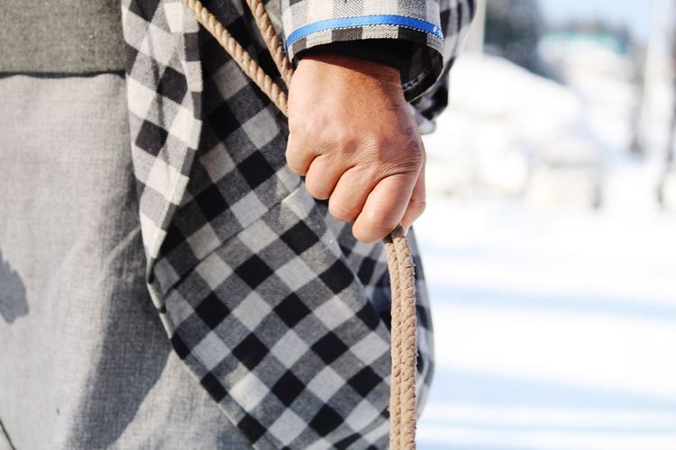 Midsection of man holding rope