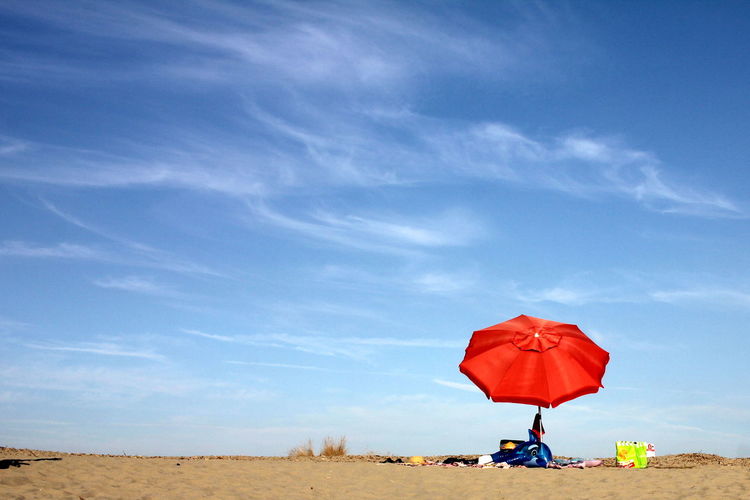 Man with umbrella against blue sky
