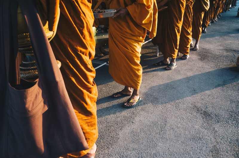 Low section of monks standing outdoors