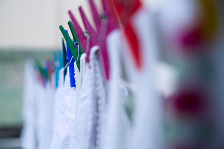 Close-up of napkins hanging by multicolored clothespins