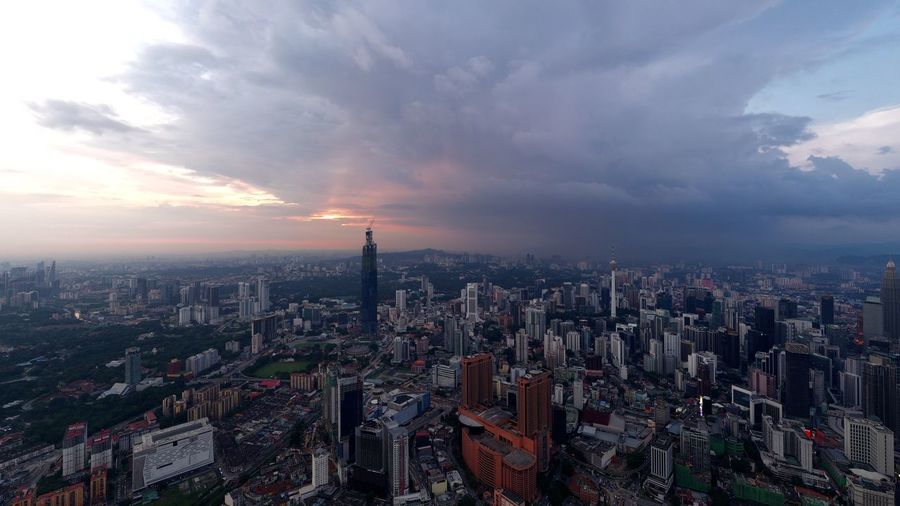 High angle view of city against cloudy sky during sunset