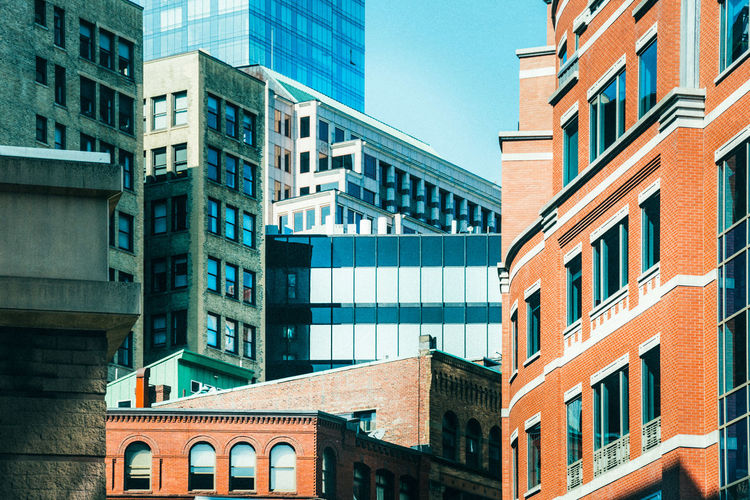 Low angle view of modern buildings against clear blue sky