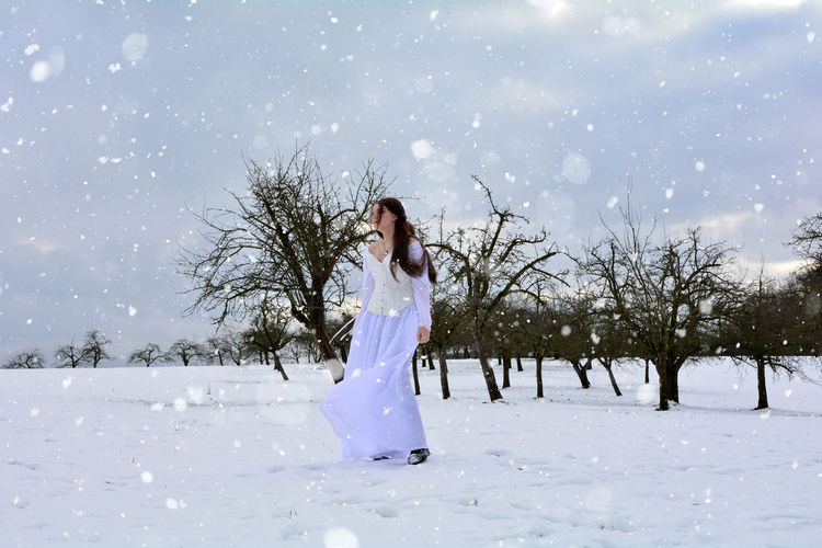 Woman standing on snow covered field