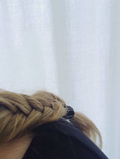 Cropped image of woman with braided hair at home