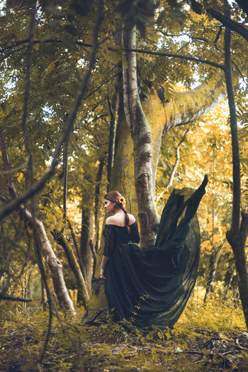 Woman sitting on hammock in forest