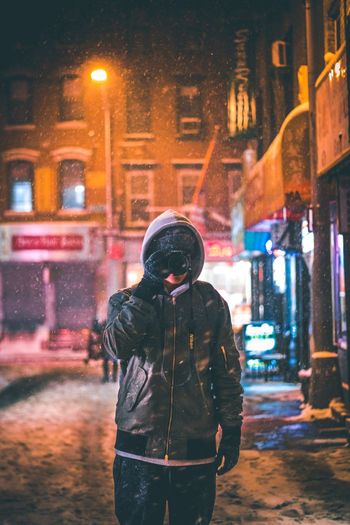 Man standing in city at night