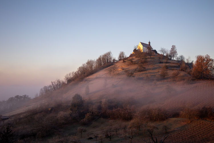 Chapel on mountain against clear sky