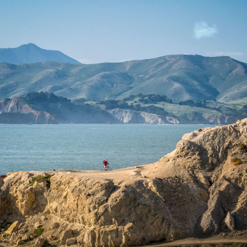 Scenic view of historic sutro baths, rocks and mountains against sky